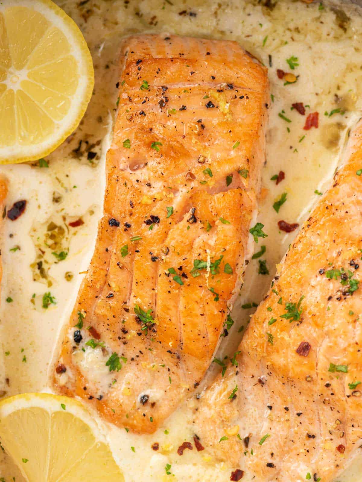 Close up of a salmon fillet in a lemon butter sauce.