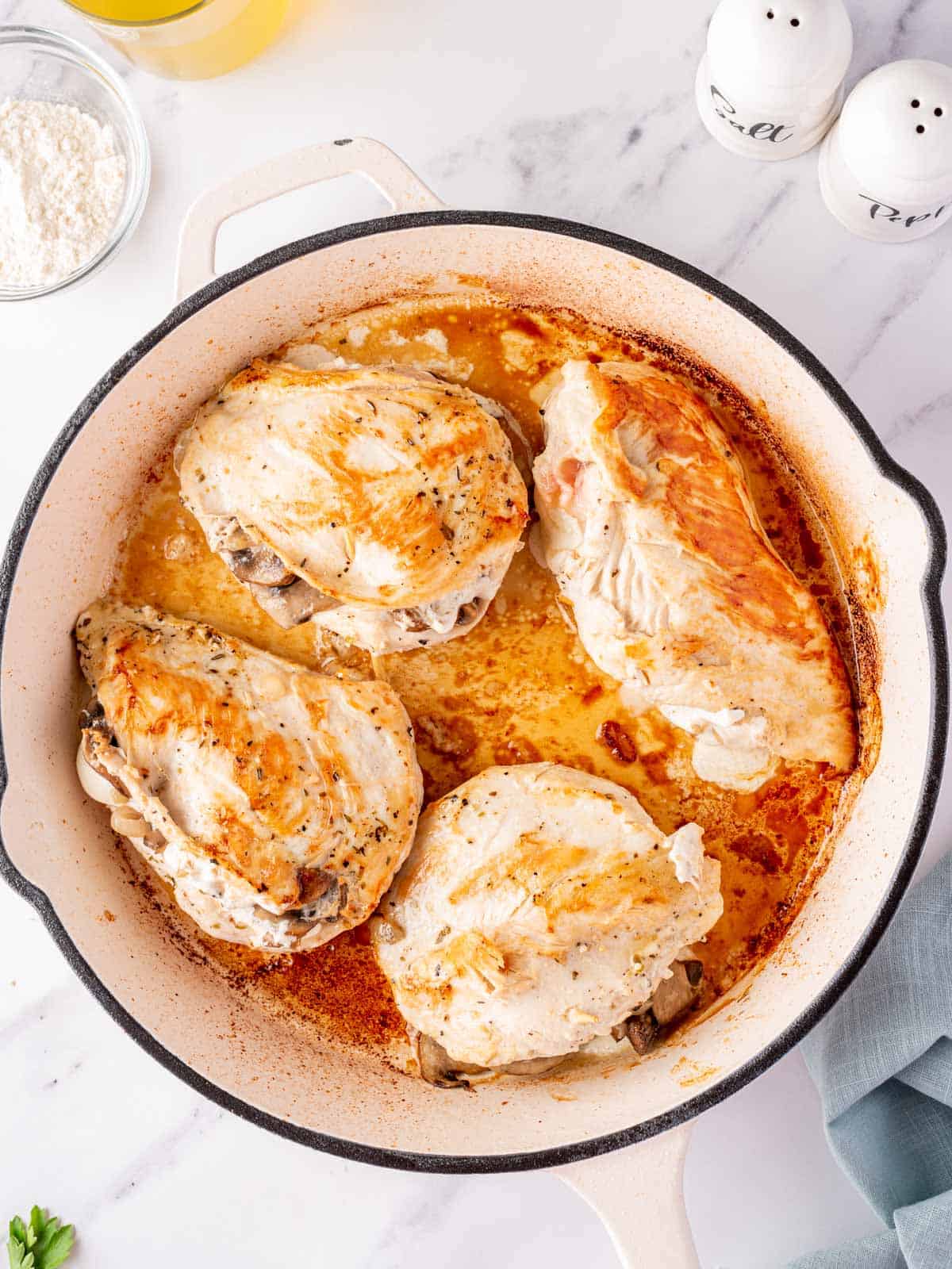 Chicken in a skillet after being seared and browned.