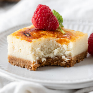creme brulee cheesecake in a plate with a bite taken out of it