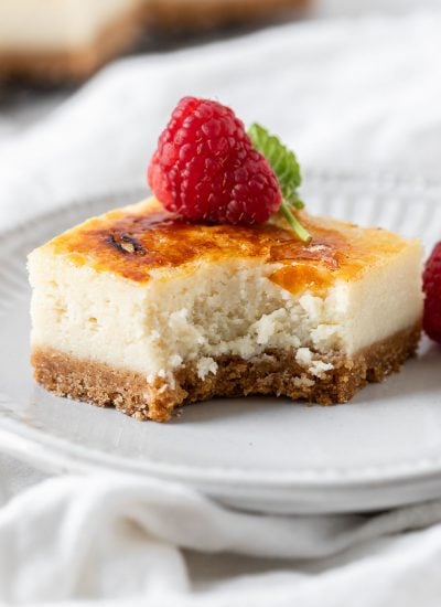 creme brulee cheesecake in a plate with a bite taken out of it