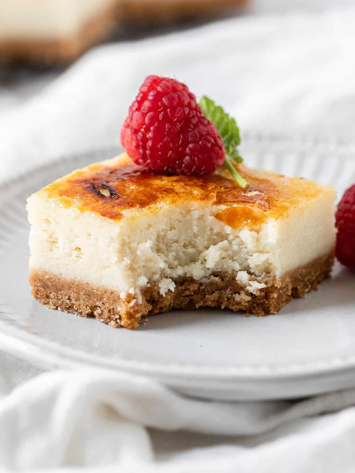 creme brulee cheesecake in a plate with a bite taken out of it