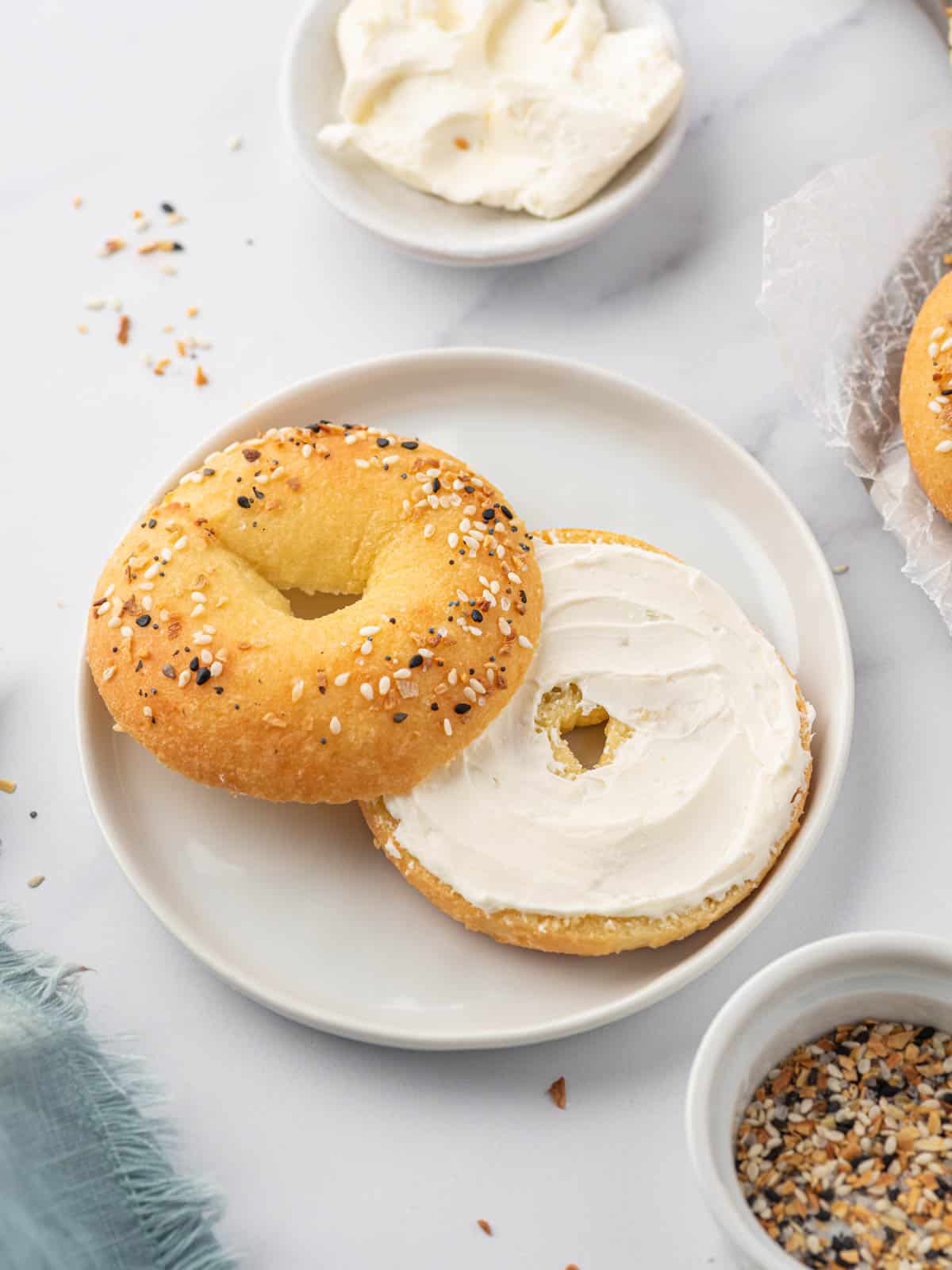 Low carb everything bagel sliced in half and smeared with cream cheese.