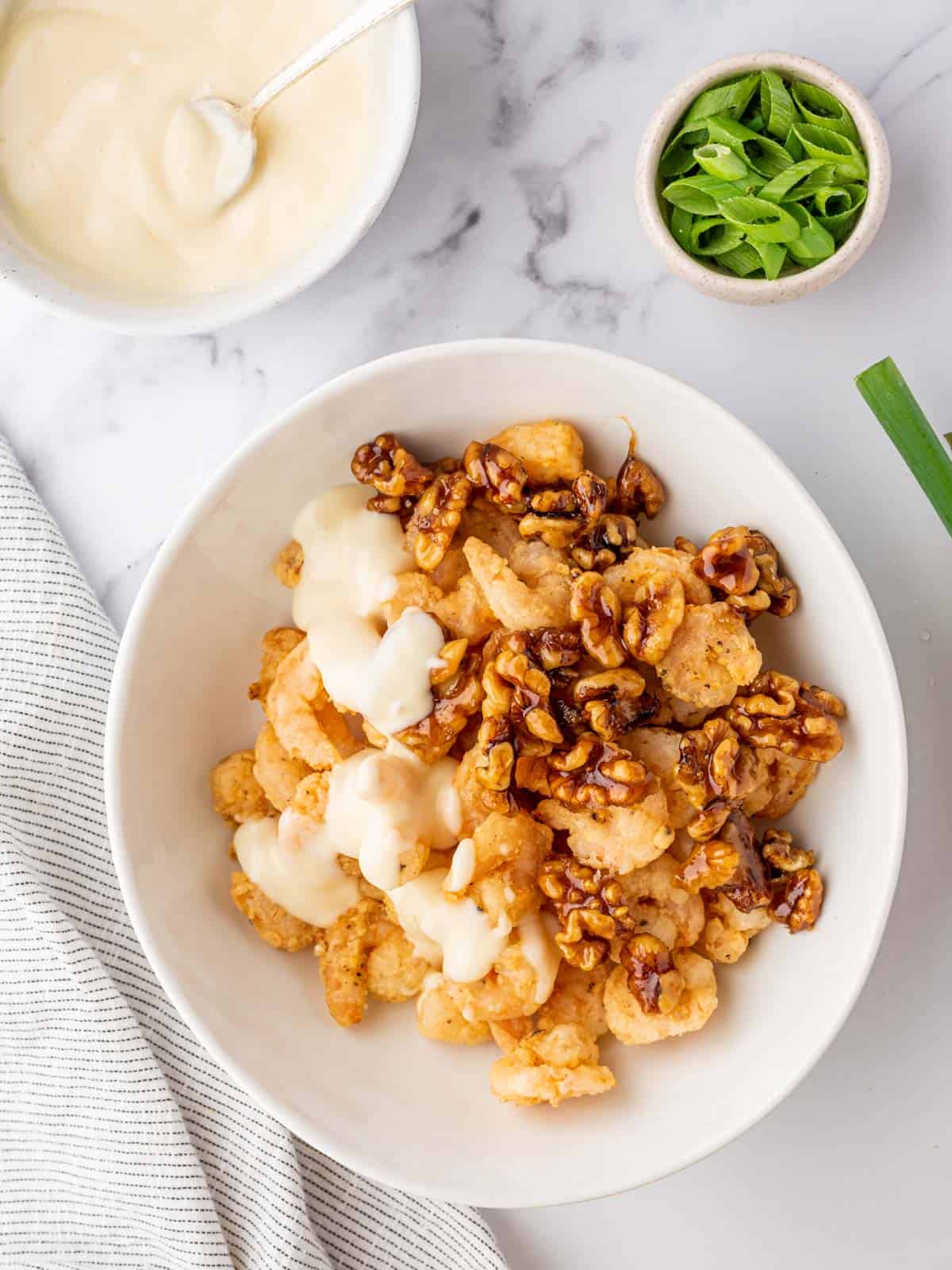 Combining the sauce, shrimp and walnuts for honey walnut shrimp.