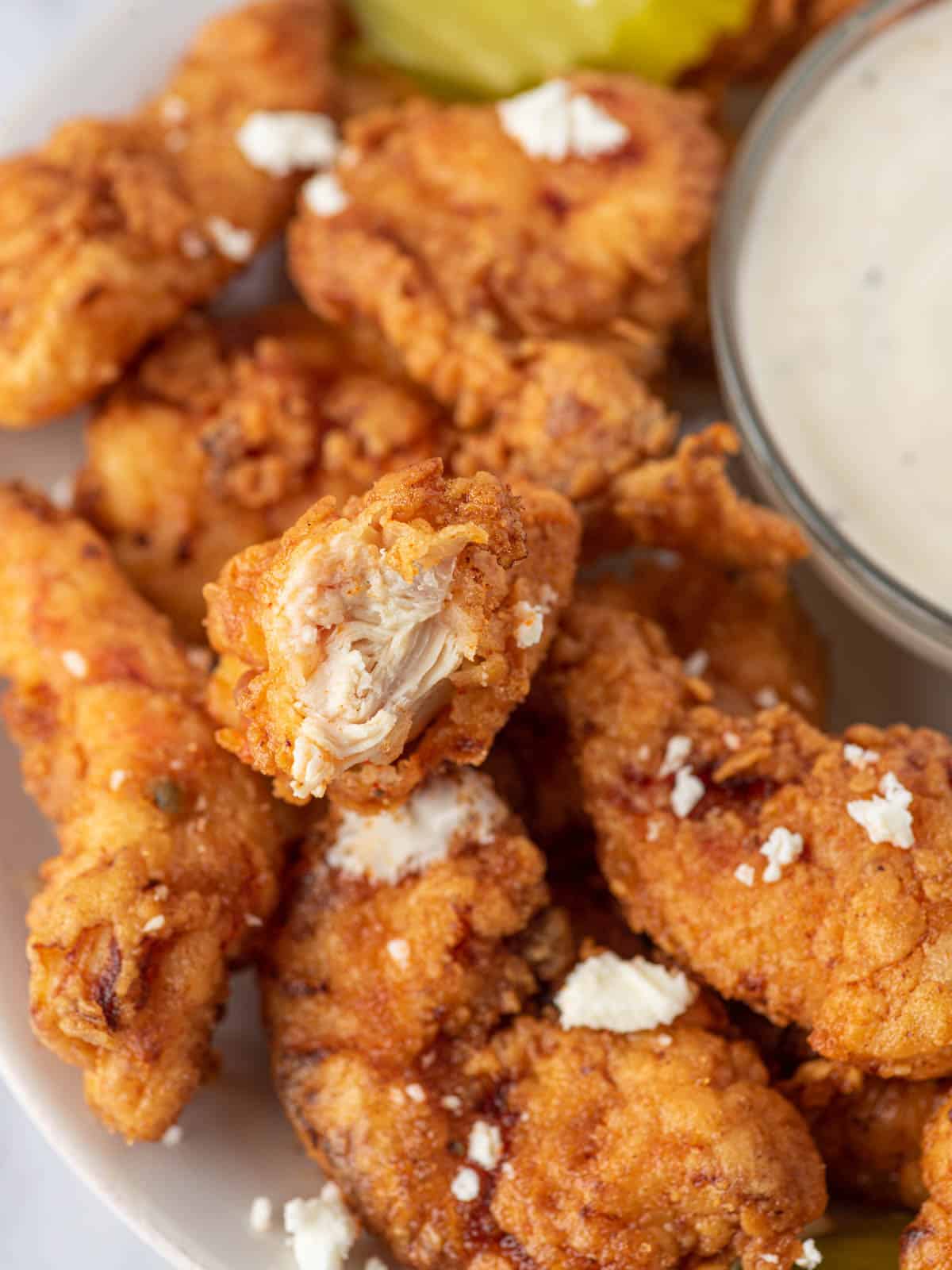 Close up of a Nashville hot chicken tender cut in half.