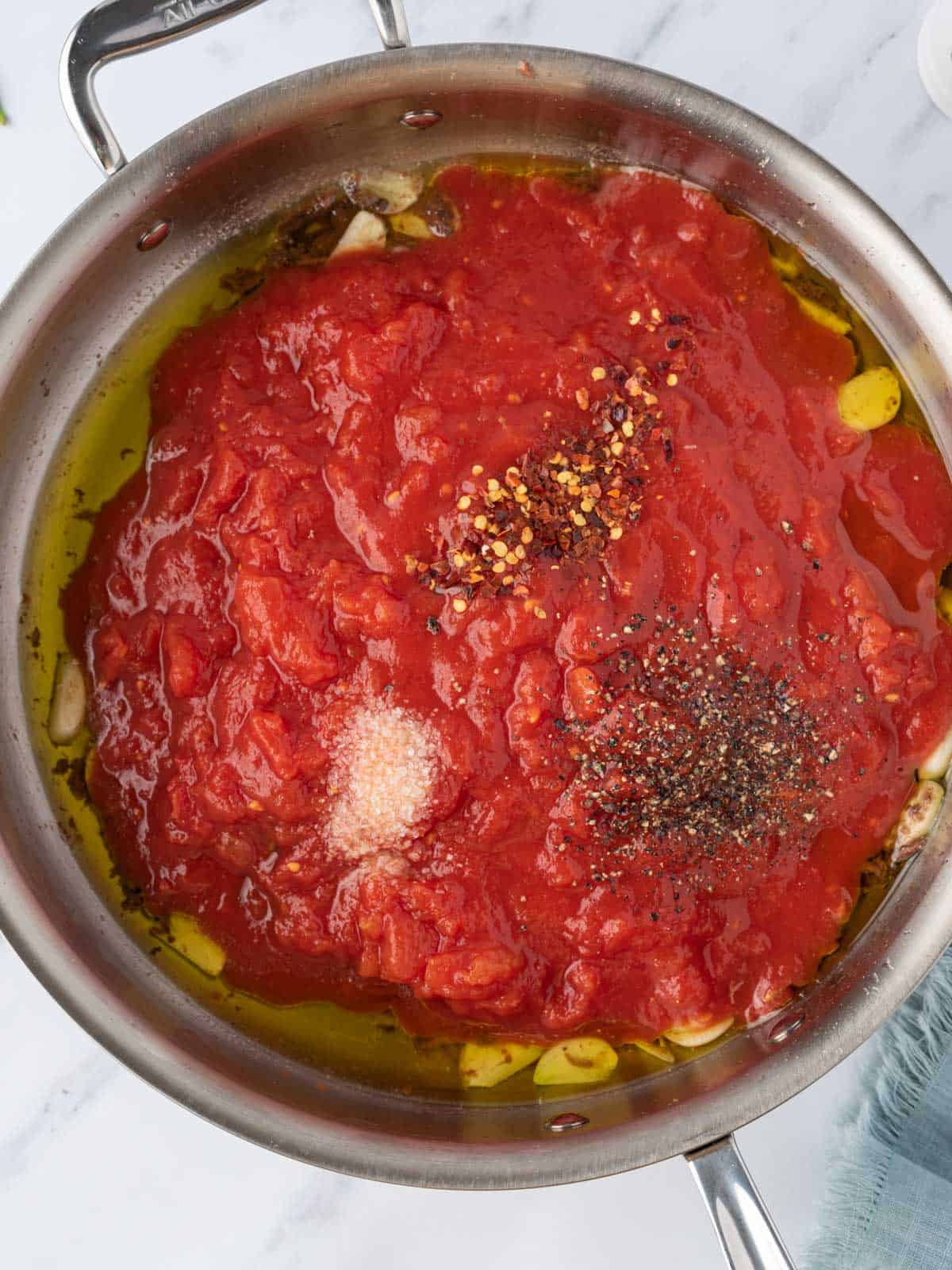 Tomato sauce and seasoning added to the pan.
