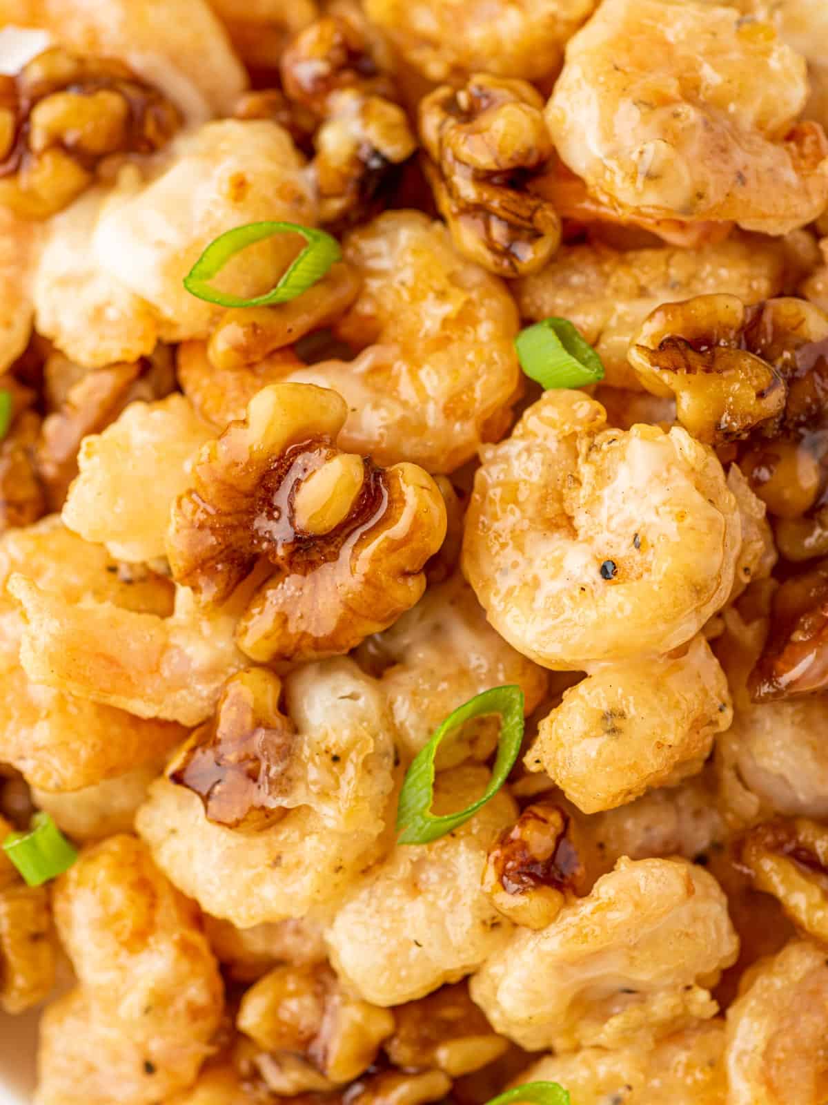 A pile of sweet honey shrimp with walnuts and green onions.