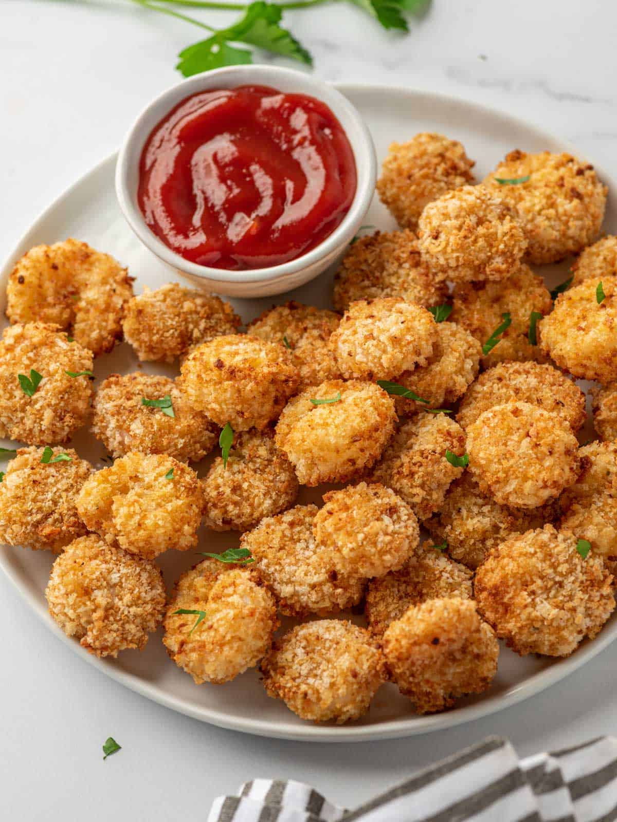 A white tray with popcorn shrimp air fryer and cocktail sauce.