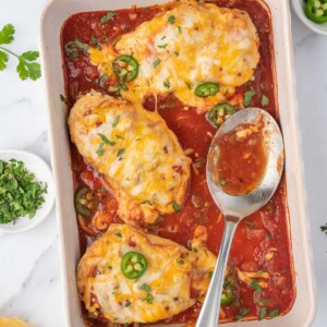 A baking dish with baked salsa chicken.
