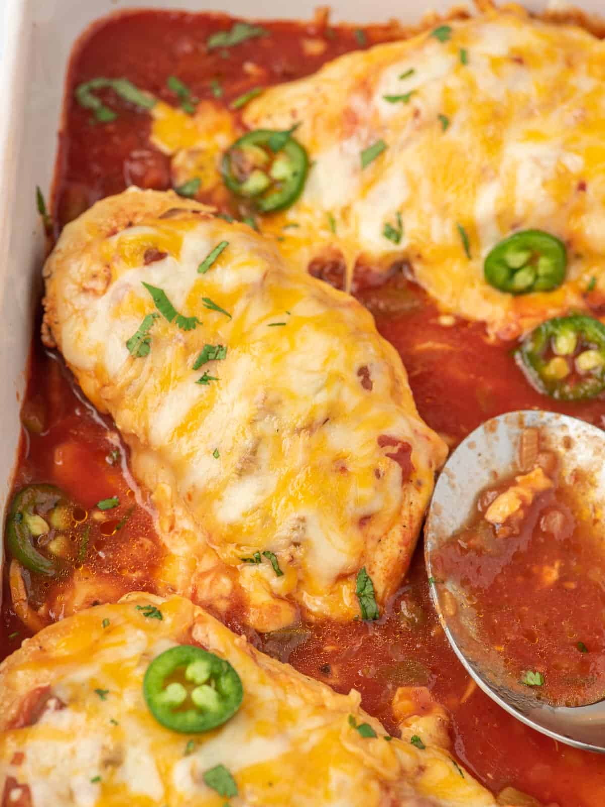 Close up of baked salsa chicken in a casserole dish.