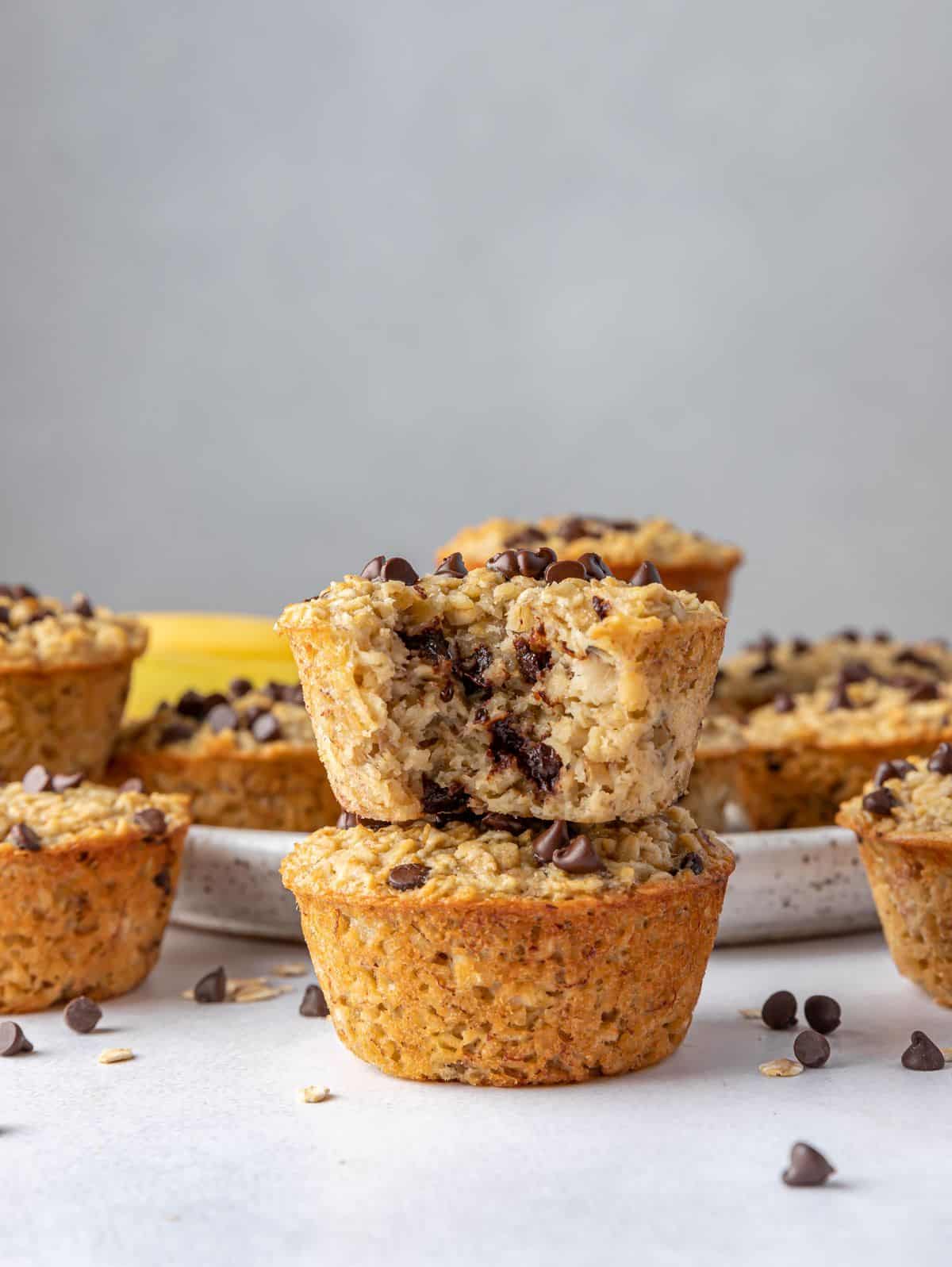 Two baked banana oatmeal cups stacked with a bite taken out of the top.