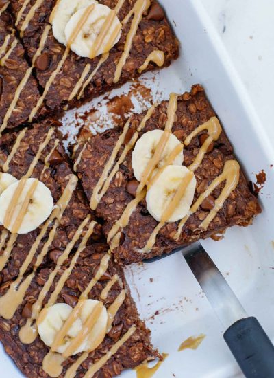 A slice of baked chocolate oatmeal sits in a baking dish.