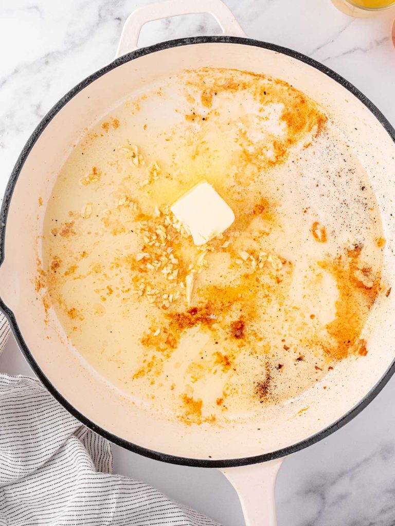 Butter and garlic added to a pan.