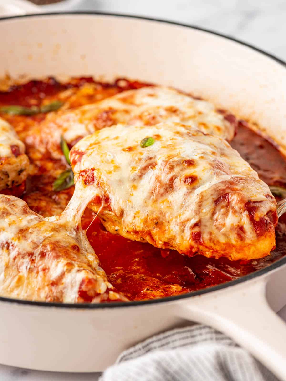 A pan with low carb chicken parmesan lifted from the pan.