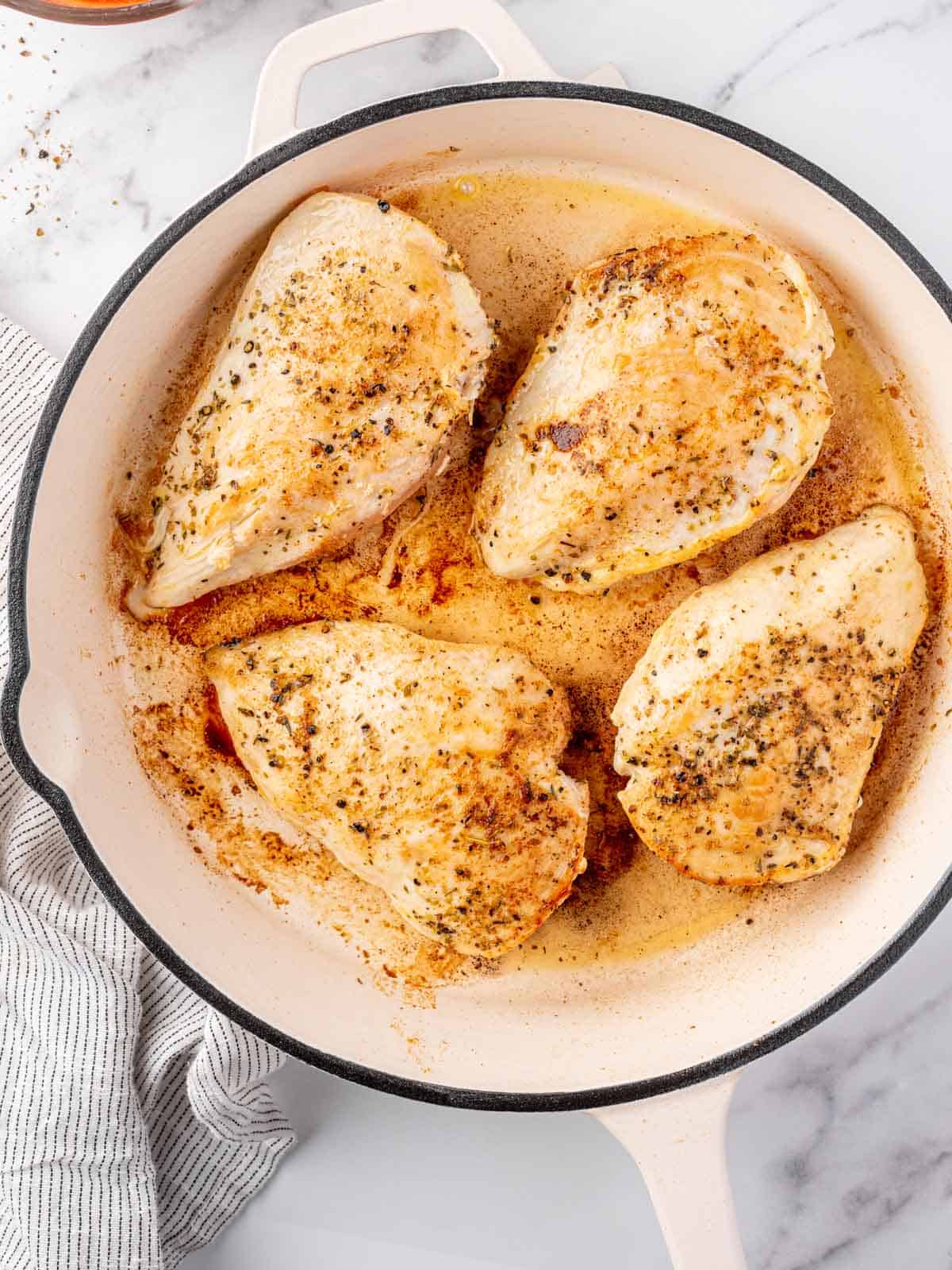 Chicken seared in a pan.