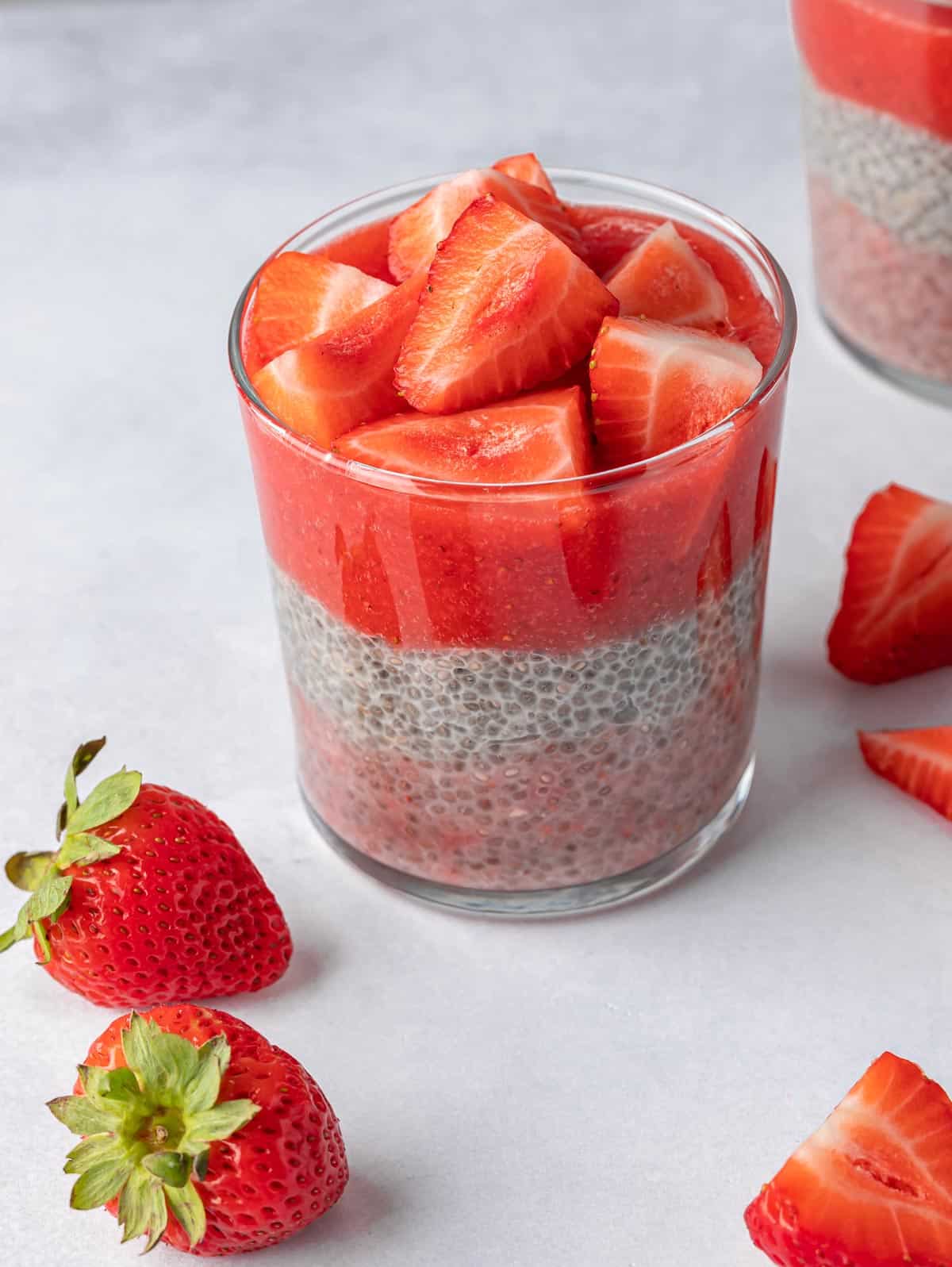 Glass of chia pudding with strawberries on top.