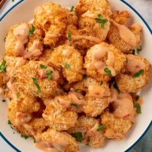 A pile of air fryer panko shrimp with bang bang sauce.