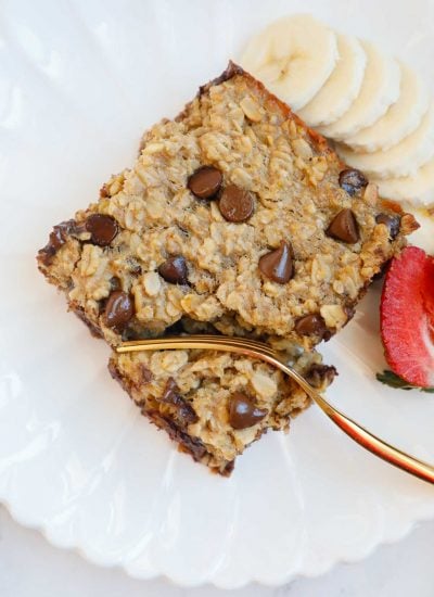 A plate with chocolate chip baked oats, fruit and a fork.