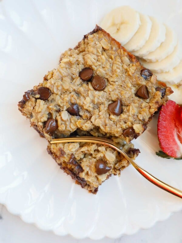 A plate with chocolate chip baked oats, fruit and a fork.