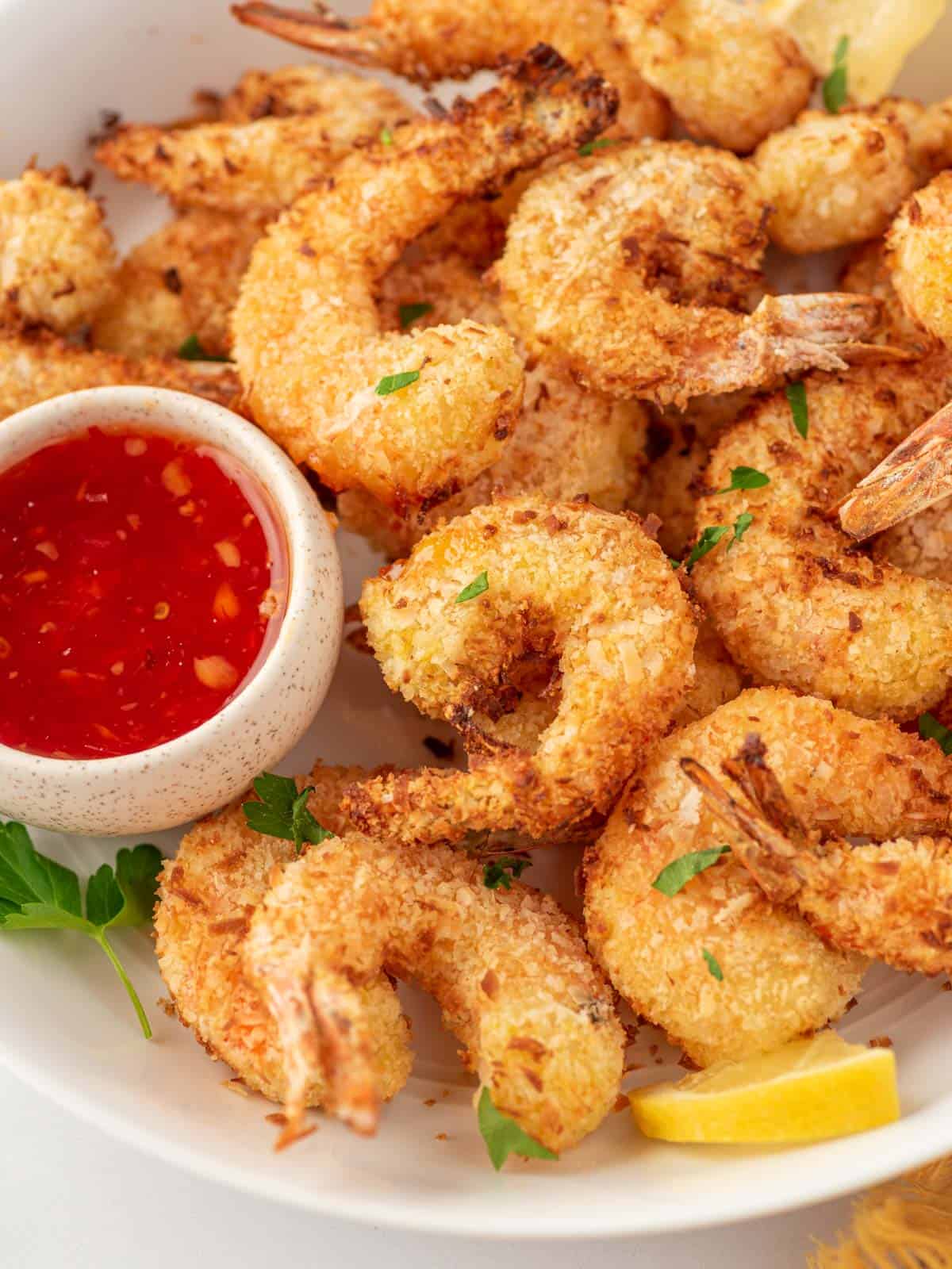 A plate of air fryer breaded shrimp with dipping sauce.