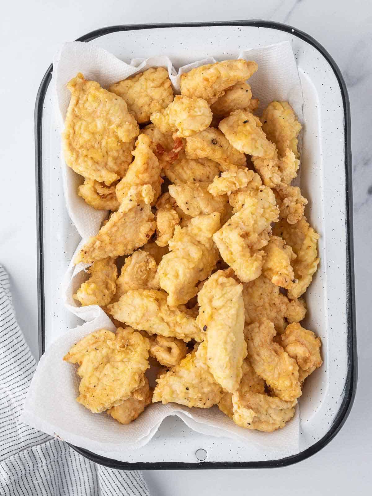 Crispy fried chicken rest in a plate on paper towels.