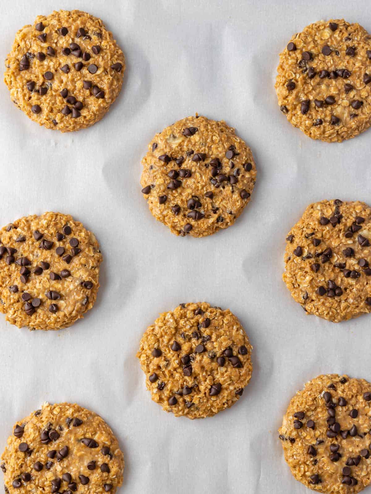 Overhead view of healthy chocolate chip oatmeal cookies on a parchment before baking.