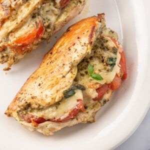 Chicken stuffed with mozzarella, pesto and tomato on a plate.