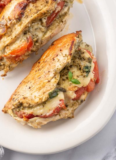 Chicken stuffed with mozzarella, pesto and tomato on a plate.