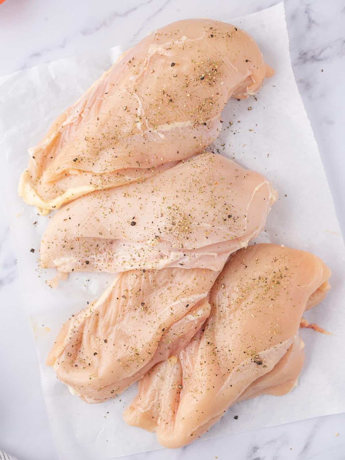 Chicken breast seasoned with salt and pepper.