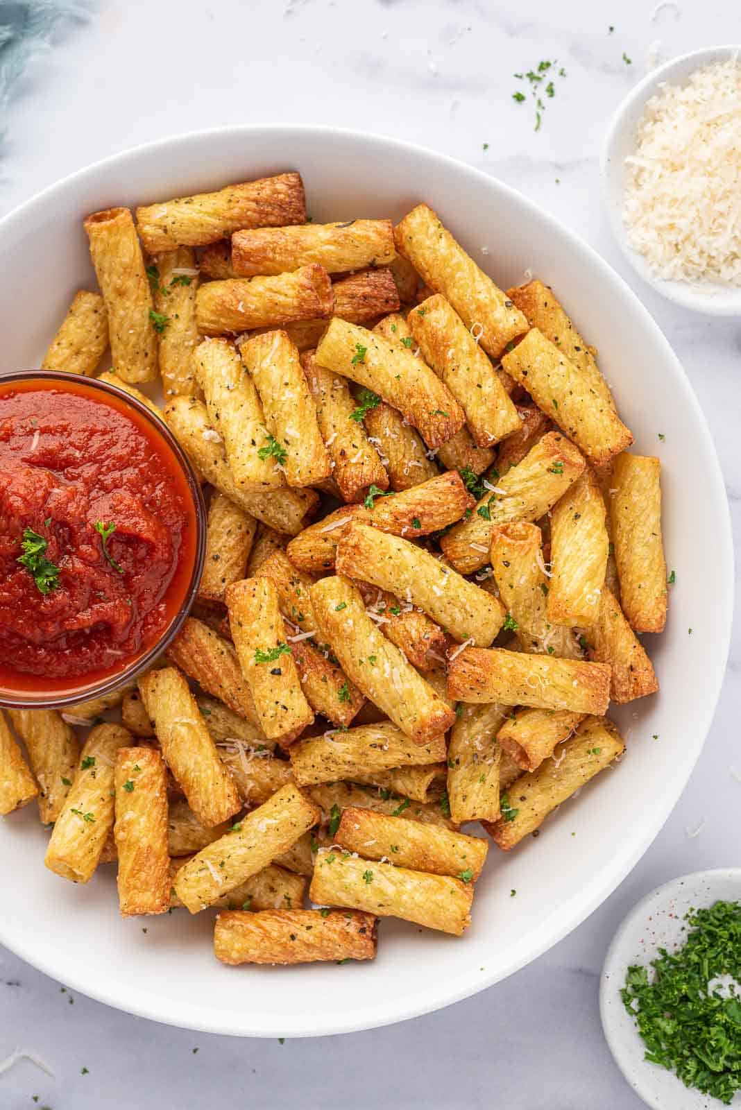 Air fryer pasta chips on a serving platter with marinara.