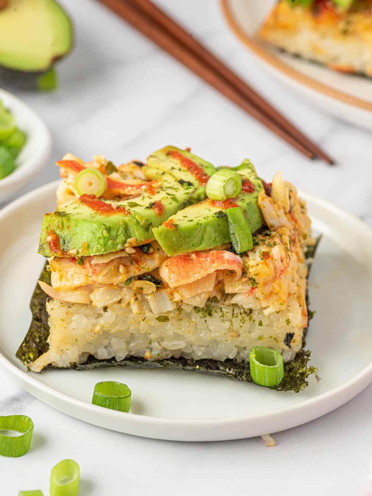 A piece of sushi bake on nori on a plate.