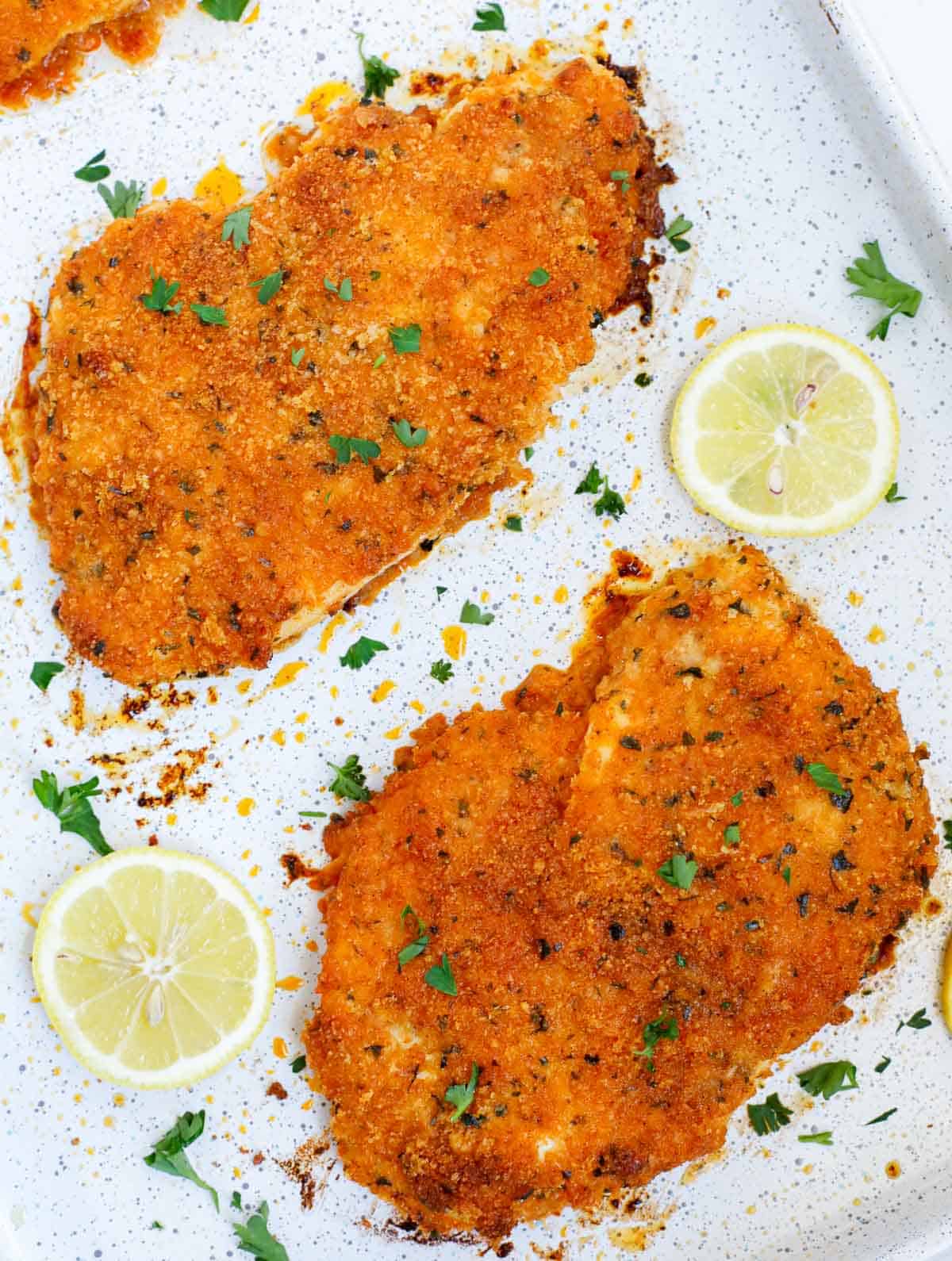 Closeup of parmesan and panko crusted chicken cutlets on a tray.