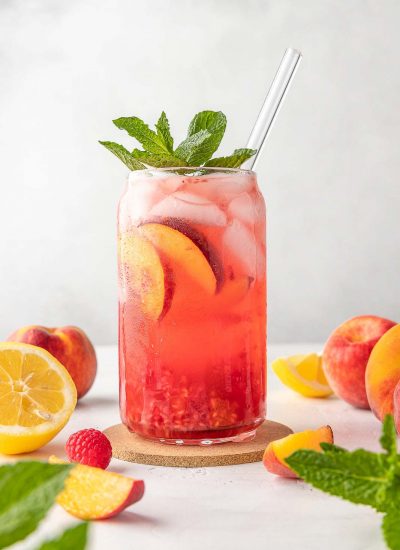 peach raspberry lemon in a cup with a glass straw