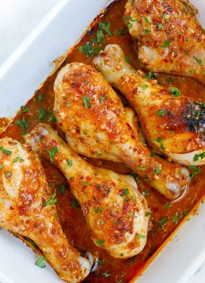 Chicken legs with honey mustard in a baking dish for serving.