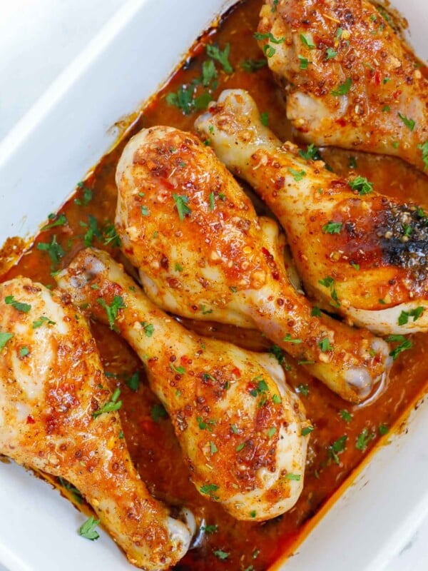 Chicken legs with honey mustard in a baking dish for serving.