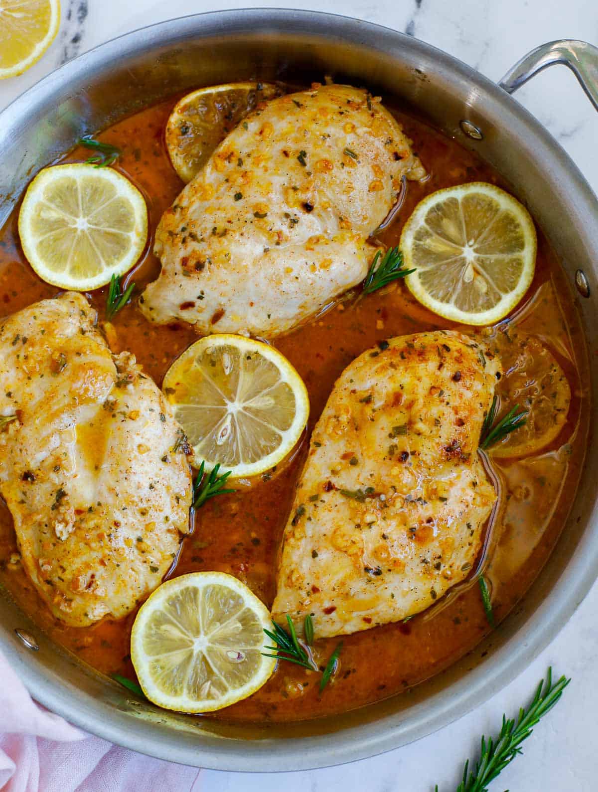 Rosemary lemon chicken breast in a skillet.