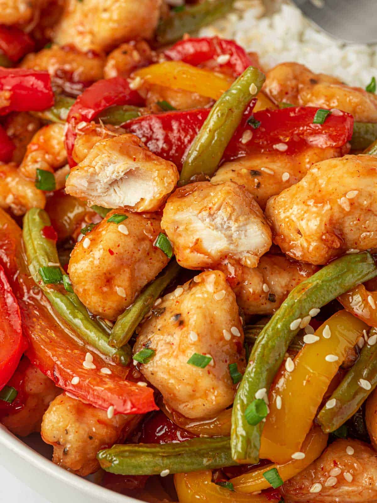 Closeup of crispy chicken stir fry and green beans.