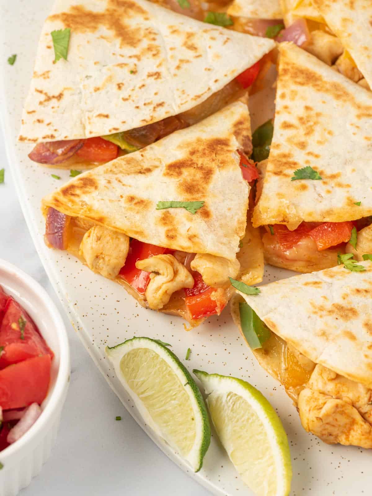 Fajita quesadillas cut into triangles and served on a plate.