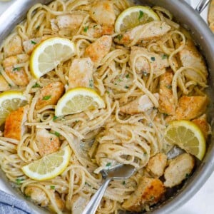 Lemon cream chicken pasta in a skillet with a fork.