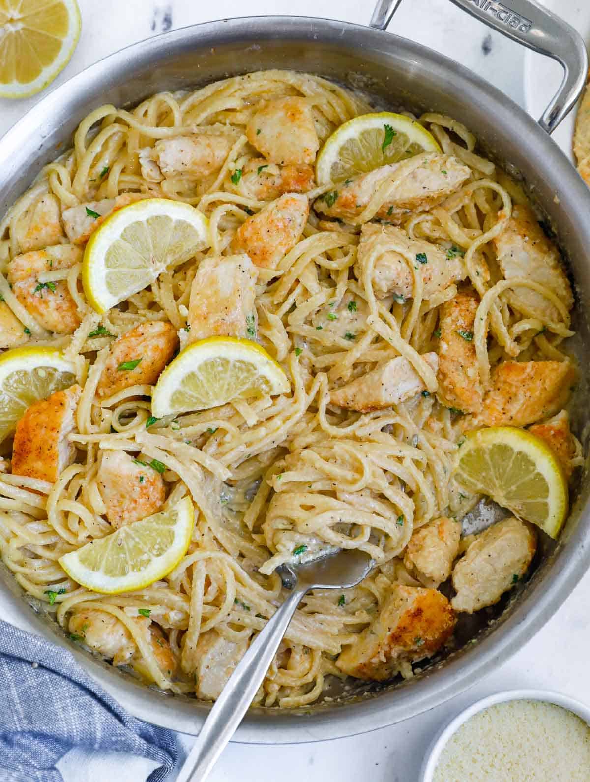 Lemon cream chicken pasta in a skillet with a fork.