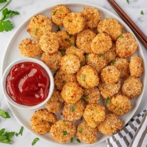 Crispy air fryer popcorn shrimp served on a plate with ketchup.
