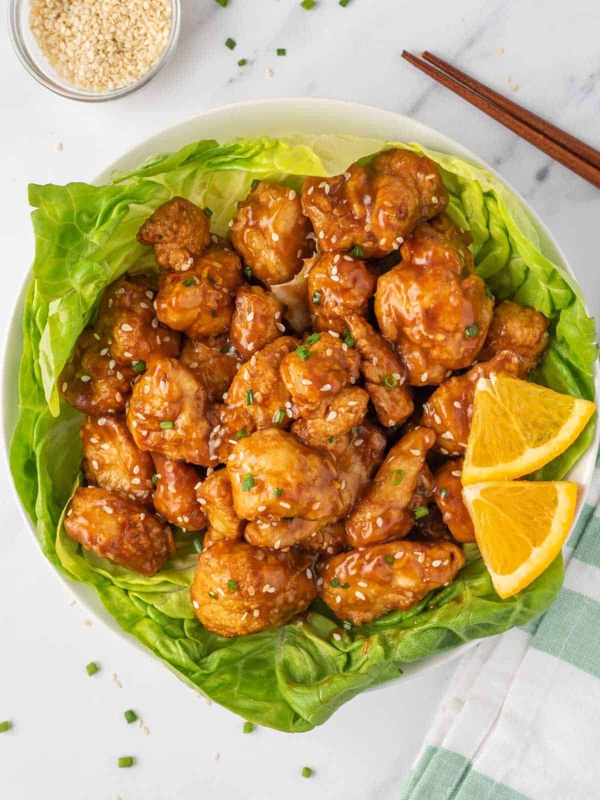 Chicken with easy orange chicken sauce served over a bed of lettuce.