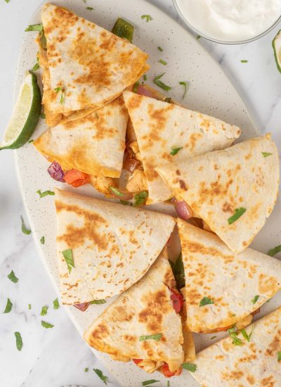 A platter of fajita quesadillas with a lime wedge.