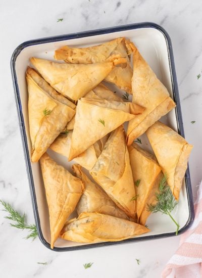 Spinach and feta triangles on a platter.