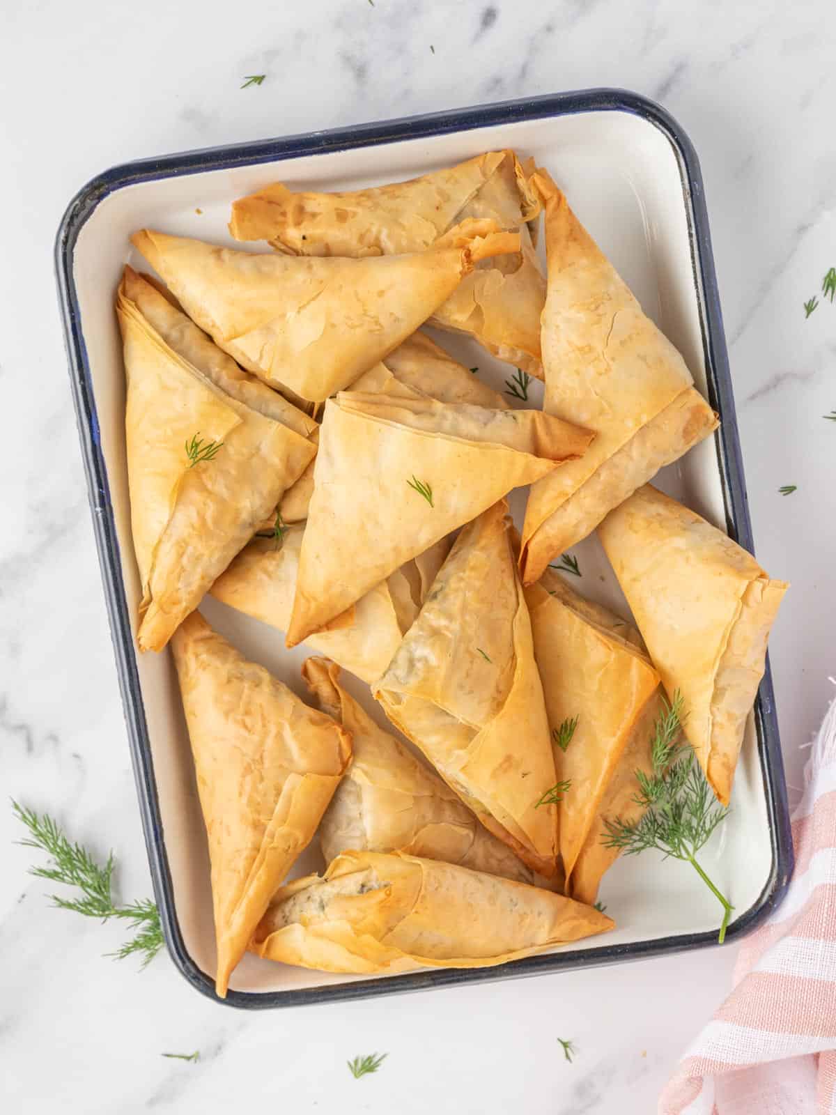 Spinach and feta triangles on a platter.