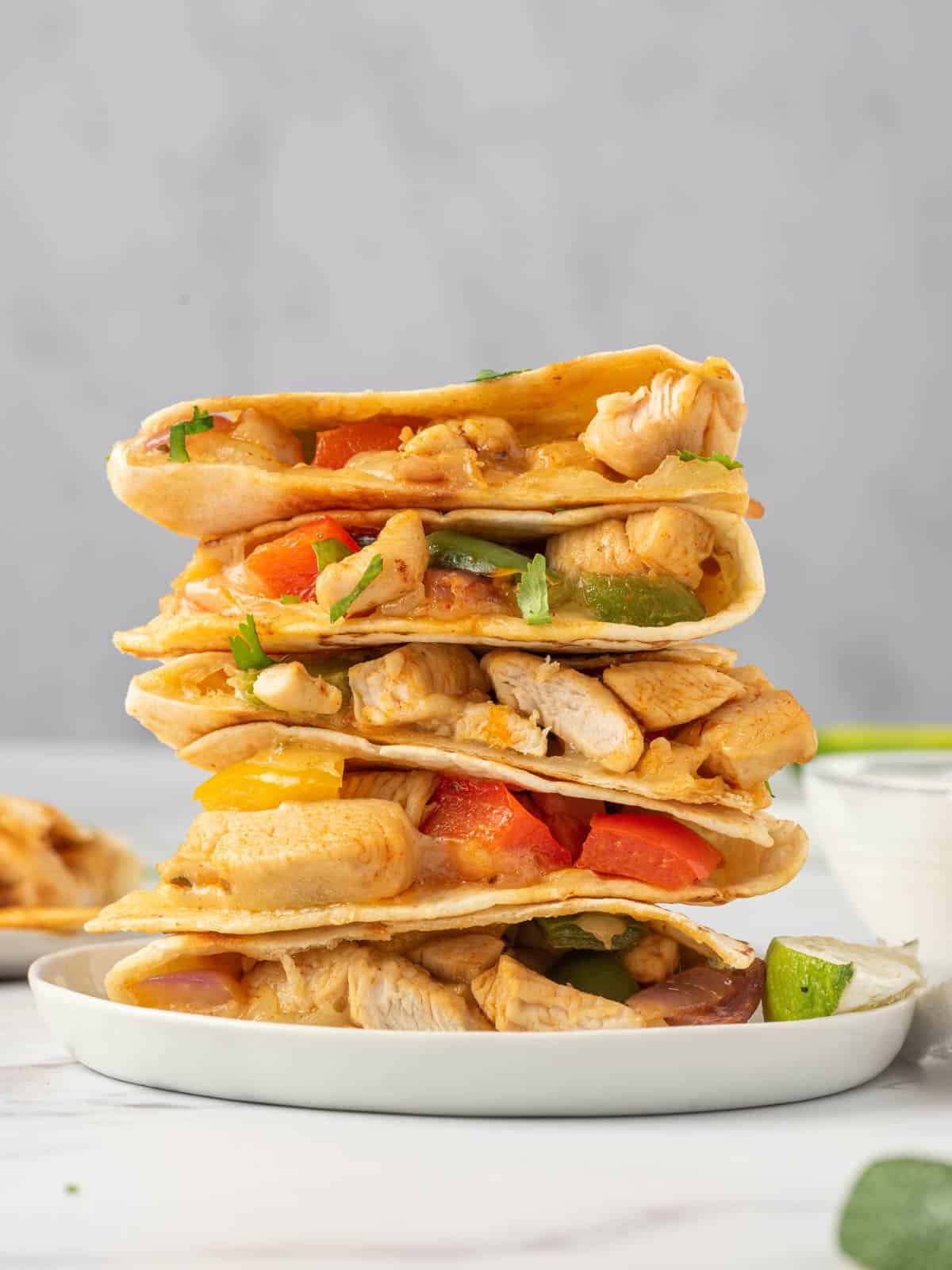 A stack of chicken and cheese quesadillas on a plate.