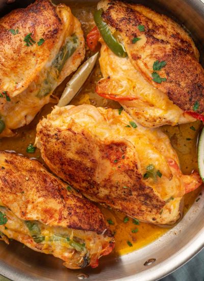 A pan full of seared chicken stuffed with peppers.