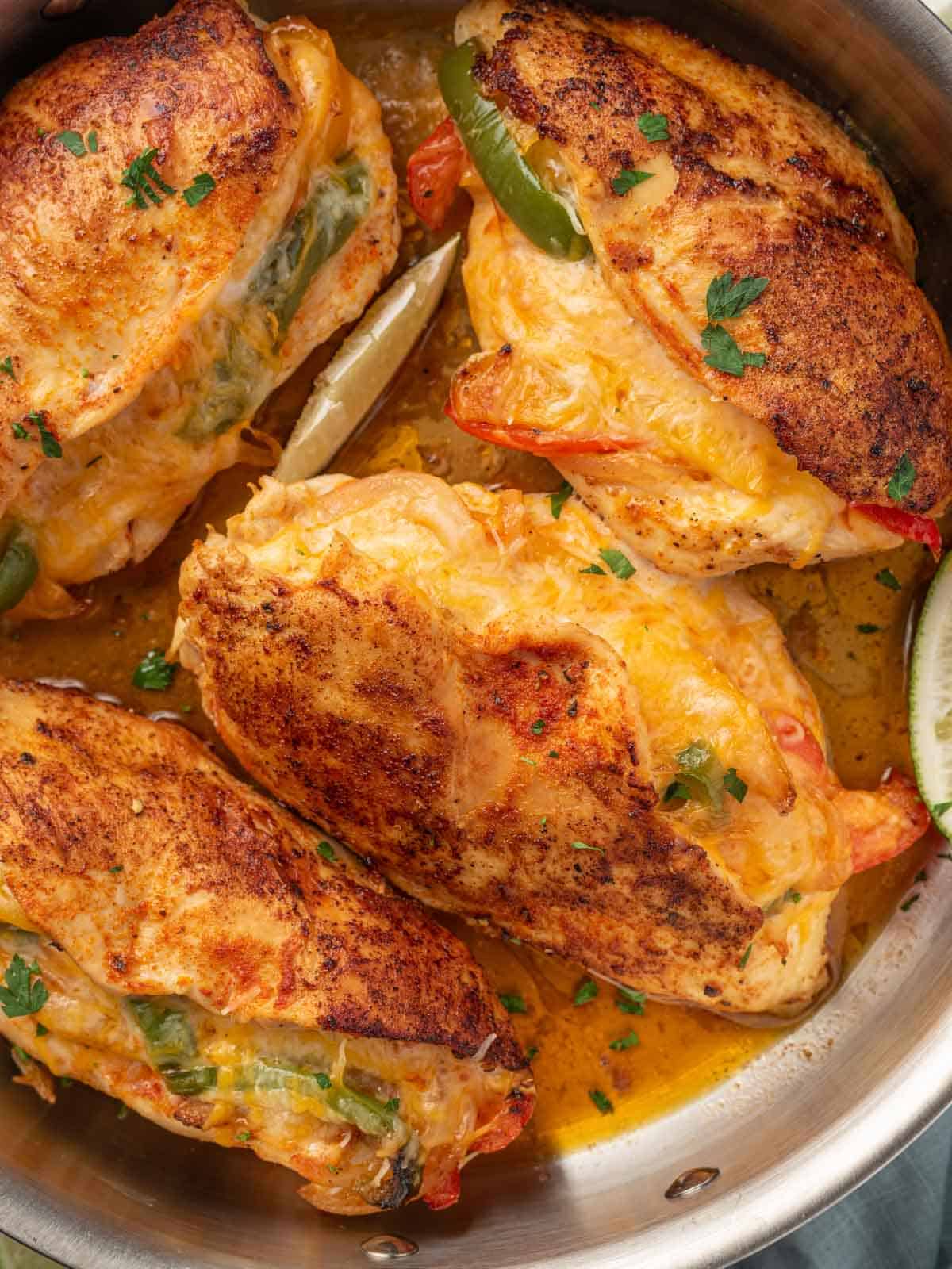 A pan full of seared chicken stuffed with peppers.