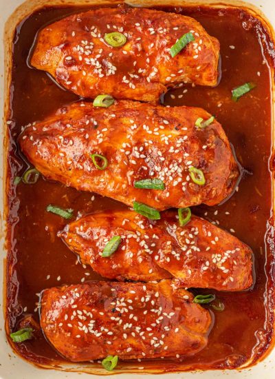 Garnished honey sriracha chicken in a baking dish.