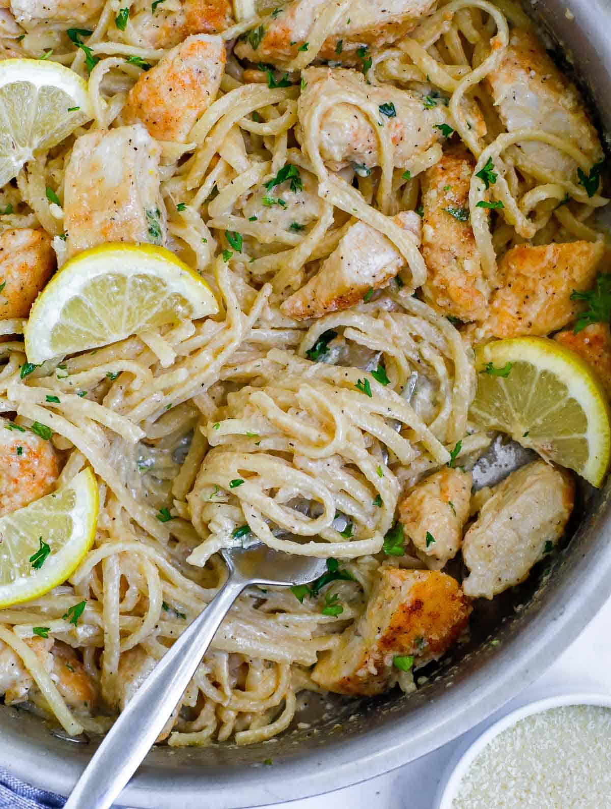 A fork filled with linguine recipes for chicken with lemon and a creamy sauce.