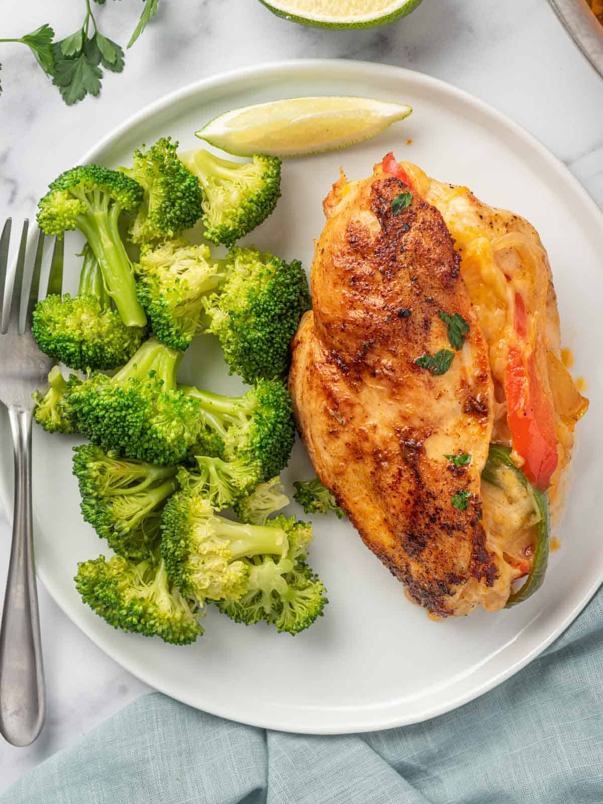 Fajita stuffed chicken on a plate with a side of broccoli.